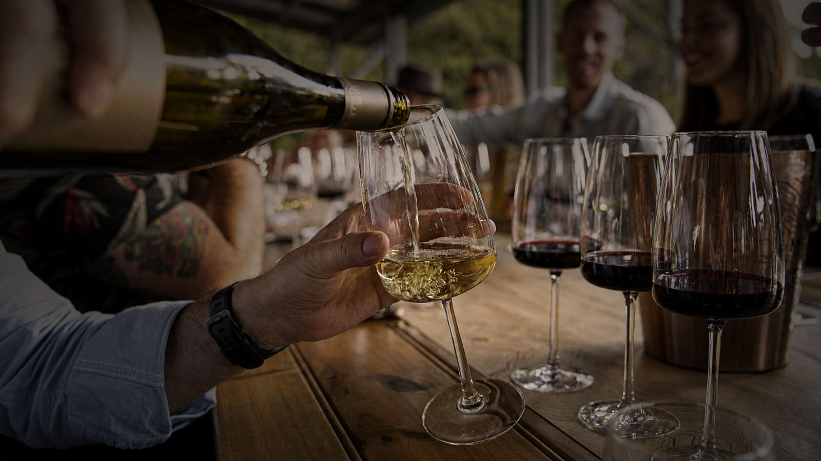 Friends enjoying a wine tasting at a warm, welcoming tasting-room table
